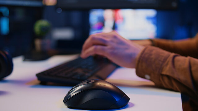 Focus on computer peripherals used by programmer to write lines of code on computer screen, with close up shot of keyboard and mouse used by developer working on fixing database errors, camera B.