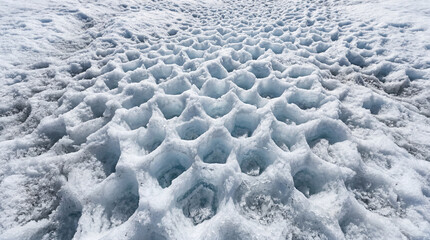 Fototapeta premium Intricate Abstract Patterns Formed By Maze Of Small Sun Cups On White Glacier Ice Surface