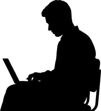 Silhouette of person using laptop computer.