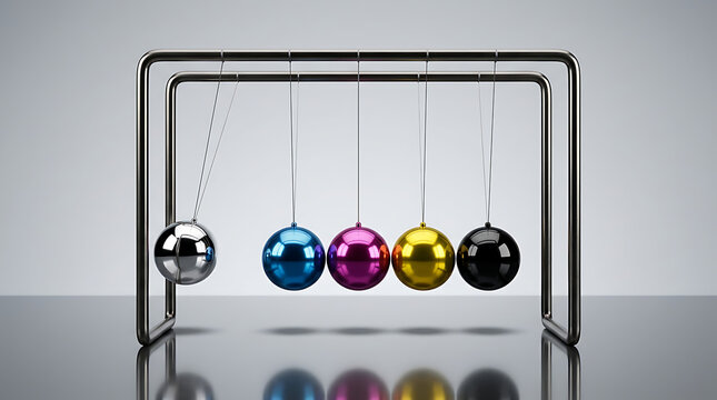 A mesmerizing Newton's cradle with colorful balls in motion on a reflective surface indoors.