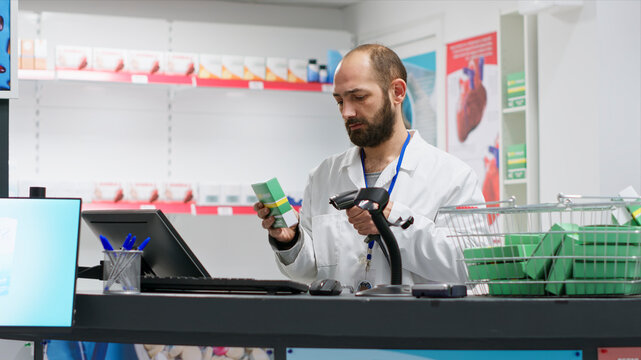 Medical retail clerk scanning supplies to register new stock, working at drugstore checkout counter to ensure medical products and vitamins inventory, pharmacist using scanner on pharmaceuticals.
