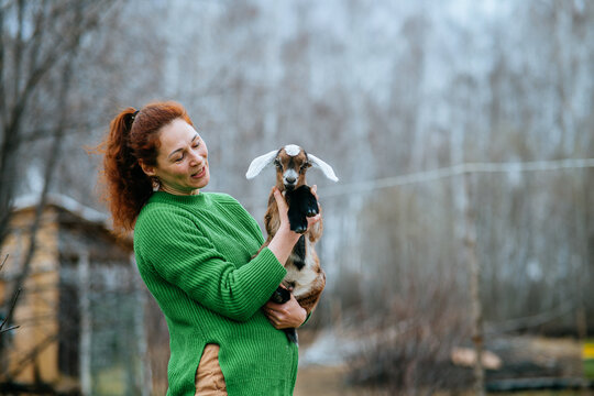 Woman Holding Nubian Goat for Veterinary Care
