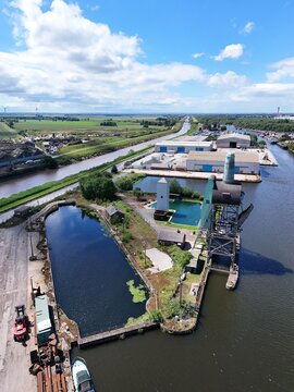 Aerial view of the historic Goole canal docks featuring the iconic coal hoist crane, industrial warehouses, and calm water in Goole, England, United Kingdom.