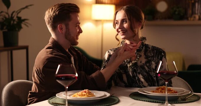 Date. Couple holding hands together at table during romantic dinner in restaurant