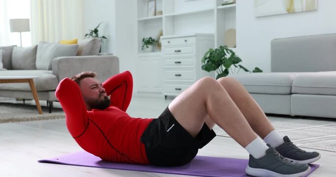Man doing exercise on fitness mat at home
