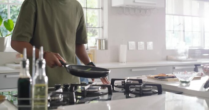 Diverse couple cooking using tablet recipe, man scooping green beans into plate, woman holding
