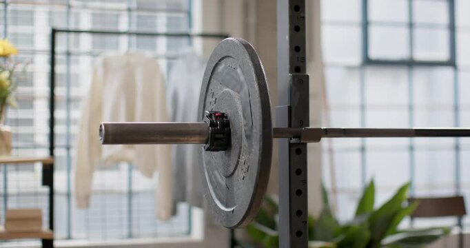 Dolly movement is pushing camera to pan and pull back, revealing loaded barbell end near windows