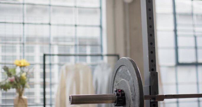 Barbell plate is being revealed in loft, camera is shifting left and back, showing locking collar