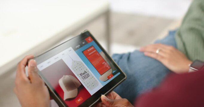 Hands are tilting and scrolling tablet on couch while viewing Black Friday deals