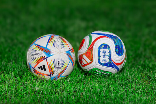 Mexico City, Mexico. June 19, 2026. Side-by-side view of official Adidas Qatar 2022 Al Rihla and 2026 FIFA World Cup soccer balls on grass.