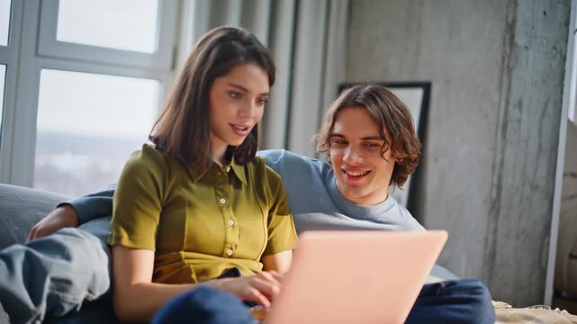 Emotional lovers using computer cuddling at bedroom closeup. Enamoured couple