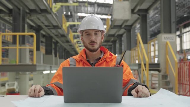 Train Depot blueprint analysis: technician meticulously examines electric train designs within vast industrial depot, leveraging technology for detailed engineering support.