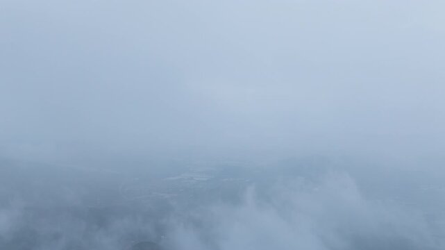 Aerial hyperlapse of thick fog and mist moving over Seongjusan Mountain in Boryeong, South Korea