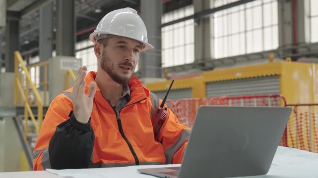 Technician uses laptop at Train Depot Maintenance Depot, operating digital tools and leveraging reflective surfaces within an industrial setting with machinery for efficient work processes.
