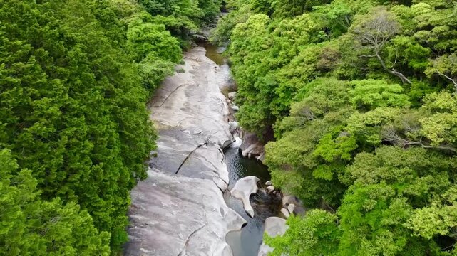 The suspension bridge and unique granite riverbed with potholes at Ayumodoshi Natural Park on Tsushima Island, Nagasaki Prefecture, Japan.