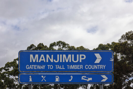 Directional road sign, Manjimup, Western Australia. Tall timber country, South West region. Famous for hardwood Karri, Marri, and Jarrah forests. Copy space, cloudy daylight sky