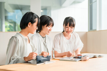 Fototapeta premium Elementary and middle school girls in casual clothes studying with friends (homework, cram school)