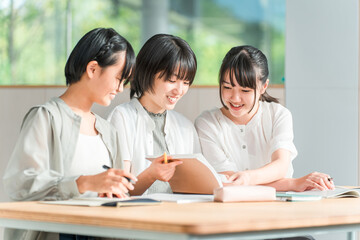 Fototapeta premium Elementary and middle school girls in casual clothes studying with friends (homework, cram school)