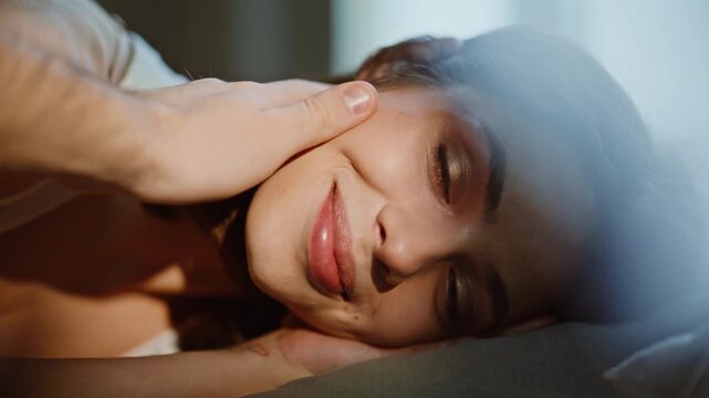 Hand stroking awaking woman at bed portrait. Young pretty lady face resting