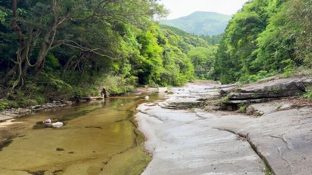 The suspension bridge and unique granite riverbed with potholes at Ayumodoshi Natural Park on Tsushima Island, Nagasaki Prefecture, Japan.