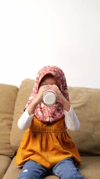 Asian Little girl child drinking milk. healthy eating a child eating breakfast kid dream concept. daughter girl in kitchen drinks yogurt milk. 
