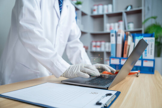 Healthcare professional using laptop with digital medical data interface in clinic. Modern health technology, electronic health records, AI healthcare, telemedicine and patient management.