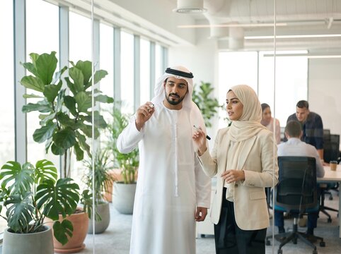 Arab business colleagues brainstorming together in modern open plan office