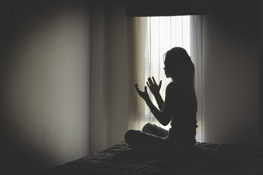A depressed woman kneels in prayer, seeking hope, healing, and strength through faith in God. Christian prayer, mental health, depression recovery, spirituality, worship.