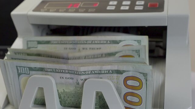 Electronic Money Counting Machine with Red Digital Display Processing a Stack of US 100 Dollar Bills
