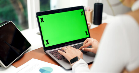 Obraz premium Laptop, green screen and hands in home for accounting, website and business research at desk. Remote work, mockup space and person with tech for typing budget, finance information and online review