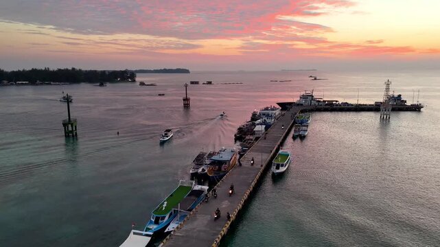 Stunning golden hour sky over the jetty in Karimunjawa Beach. Beautiful tropical island sunset landscape.