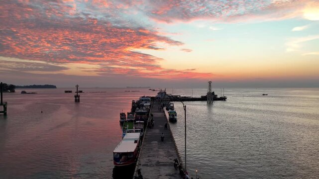 Stunning golden hour sky over the jetty in Karimunjawa Beach. Beautiful tropical island sunset landscape.