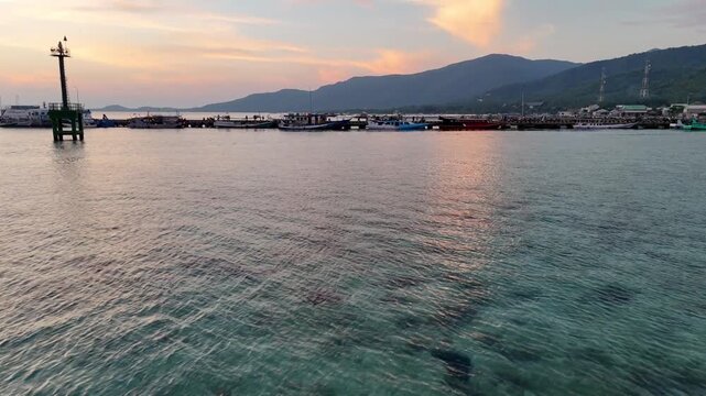 Stunning golden hour sky over the jetty in Karimunjawa Beach. Beautiful tropical island sunset landscape.