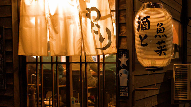 Traditional Japanese Izakaya Entrance with Glowing Lantern and Noren Curtains