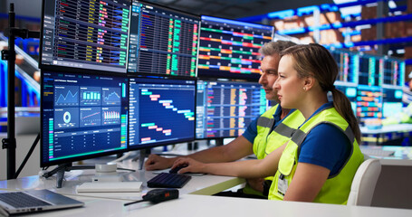 Fototapeta na wymiar Two Coworkers Studying Logistics Data On Computer Screens