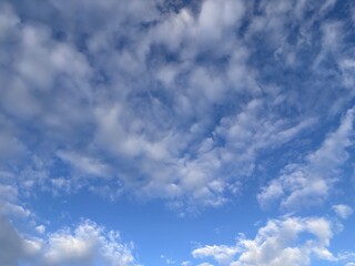 Fototapeta premium Peaceful deep blue sky and soft white clouds. Conceptual natural background representing freedom, tranquility, hope, and a bright positive future.