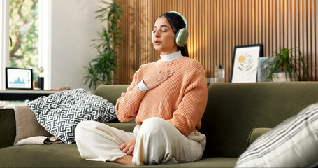 Woman, breathe and headphones on sofa for meditation, spiritual healing or holistic audio for zen....