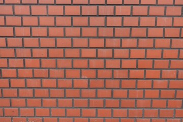 Fototapeta premium Uniform red orange brick wall exterior texture background photo