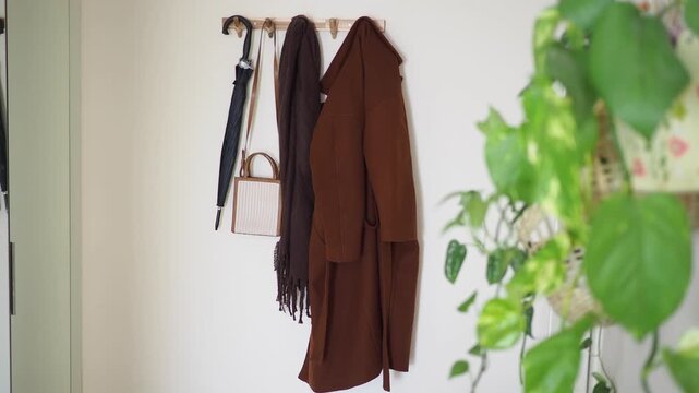 Coat and umbrella hang on a hook in a simple room