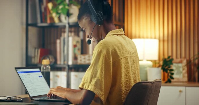 Headset, laptop screen and black woman in home office for help, technical support or remote work. IT assistance, customer care and happy freelancer typing with tech, software advice or talk at night