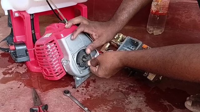 Mechanic Cleaning Friction Material Debris From Two Stroke Sprayer Engine Clutch Pads Using Sandpaper Close Up
