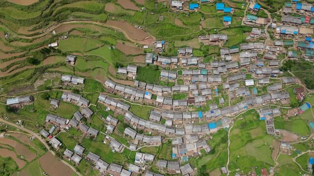 High vertical top down birds eye view of dense rural village roofing patterns and layout
