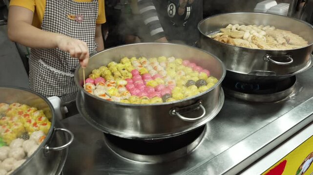 Colorful Tang Yuan Fish Balls Cooking in Large Steaming pot at Chinese Street Food Stall