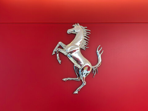 Kuala Lumpur, Malaysia - April 12, 2026: Chrome Ferrari Prancing Horse Cavallino Rampante Sculpture on Red Showroom Wall
