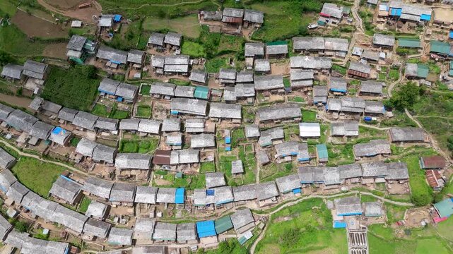top-down birds eye view of dense rural mountain village with uniform zinc sheet roofing patterns