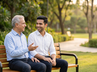 Obraz premium senior indian father and adult son sharing supportive moment on park bench representing family bonding and emotional wellbeing concept