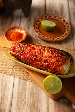 Elote Asado, Grilled corn. A typical Mexican street food, it's a charcoal-grilled corn cob eaten with lime and piqu&iacute;n chili powder.