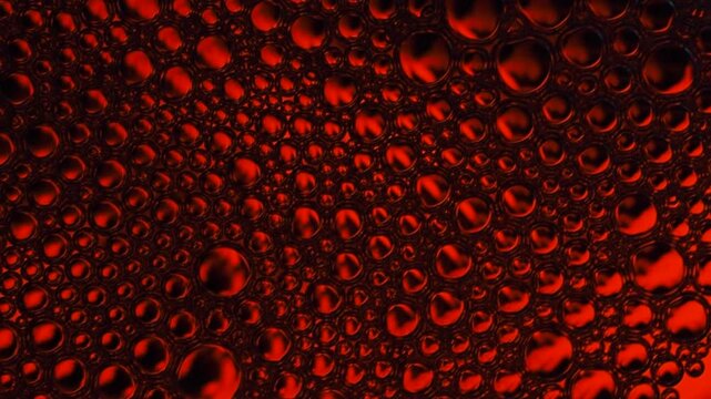 Red bubbles forming an intricate abstract pattern close up, appearing as lava or oil