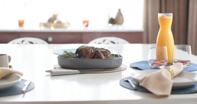 Camera is starting push-in on cue, tightening framing and showing roast with juice carafe on table