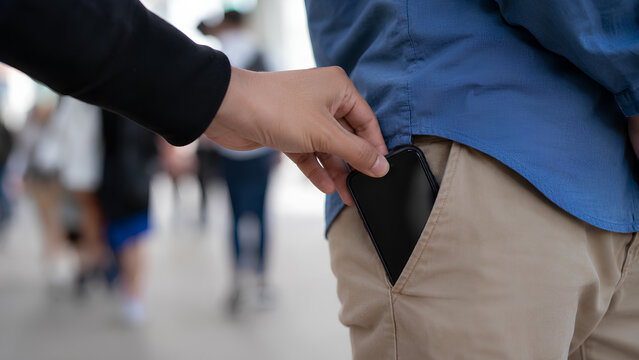 Pickpocket Thief Stealing Black Wallet from Man's Back Pocket in Crowded Busy Street - Close-up of Criminal Hand Stealing in Public Place